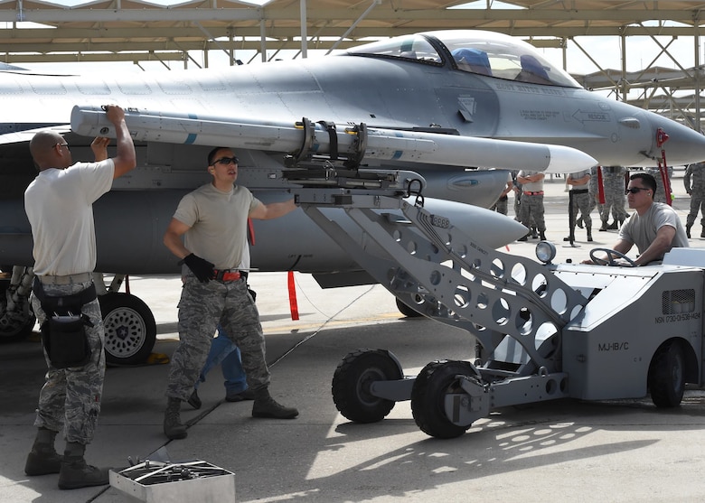 Tech. Sgt. Mark Nash (left), Tech. Sgt. Federico Barrios (center) and Senior Airman Robert Satter (right), aircraft armament systems technicians, load an inert AIM-120, advanced medium-range air-to-air missile onto the wingtip of an F-16 Fighting Falcon during the loading portion of the 56th Fighter Wing’s quarterly load crew of the quarter competition at Luke Air Force Base, Arizona, April 8, 2016. Nash, Barrios and Satter are members of the Texas Air National Guard’s 149th Fighter Wing, headquartered at Joint Base San Antonio-Lackland, Texas, which is currently operating at Luke while San Antonio’s Kelly Field undergoes runway repairs.