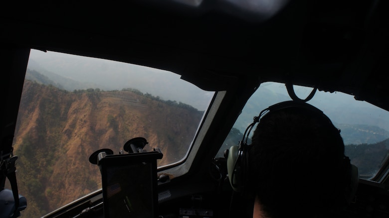 Hawaii Air National Guard C-17 Globemaster III pilot, Capt. Skip Saito examines Philippine terrain during a low flying maneuver exercise at Balikatan 2016, Clark Air Field, Philippines, April 15, 2016. Balikatan, which means shoulder to shoulder in Filipino, is an annual bilateral training exercise aimed at improving the ability of Philippine and U.S. military forces to work together during planning, contingency and humanitarian assistance and disaster relief operations. (U.S. Air National Guard photo by Tech. Sgt. Andrew Jackson/released)
