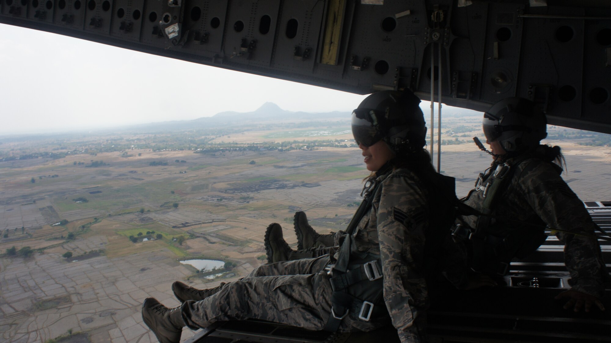 Two airmen enjoy the view out of the rear door of a C-17 Globemaster III aircraft during a low flying maneuver conducted during exercise Balikatan 2016, Clark Air Field, Philippines, April 15, 2016. The aircraft was crewed by airmen from the Hawaii Air National Guard's 204th Airlift squadron and active duty 535th Airlift squadron. Balikatan, which means shoulder to shoulder in Filipino, is an annual bilateral training exercise aimed at improving the ability of Philippine and U.S. military forces to work together during planning, contingency and humanitarian assistance and disaster relief operations. (U.S. Air National Guard photo by Tech. Sgt. Andrew Jackson/released)
