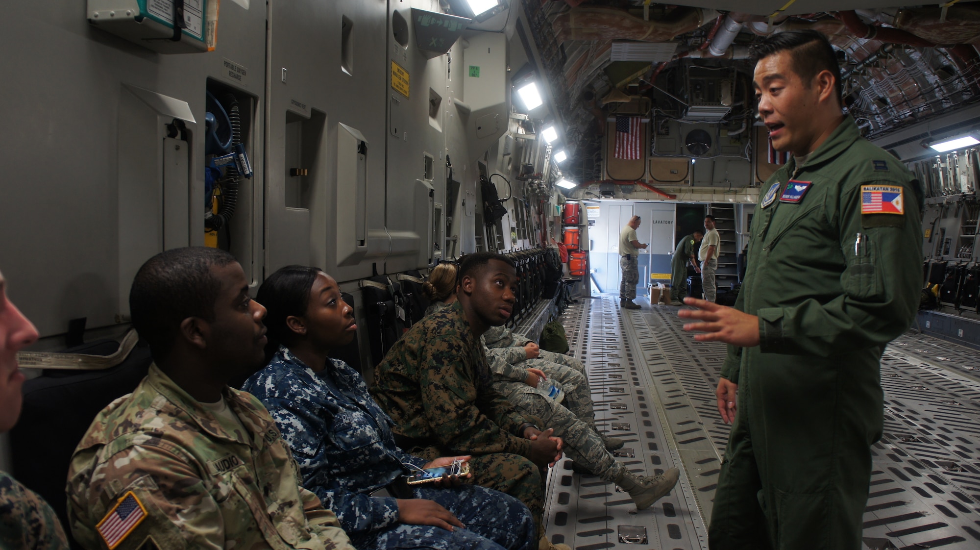 U.S. Air Force Capt. Reinier Villanueva, pilot with the 204th Airlift squadron conducts a safety brief with passengers before a low flying maneuver flight on a C-17 Globemaster III during exercise Balikatan 2016, Clark Air Field, Philippines, April 15, 2016. Balikatan, which means shoulder to shoulder in Filipino, is an annual bilateral training exercise aimed at improving the ability of Philippine and U.S. military forces to work together during planning, contingency and humanitarian assistance and disaster relief operations. (U.S. Air National Guard photo by Tech. Sgt. Andrew Jackson/released)