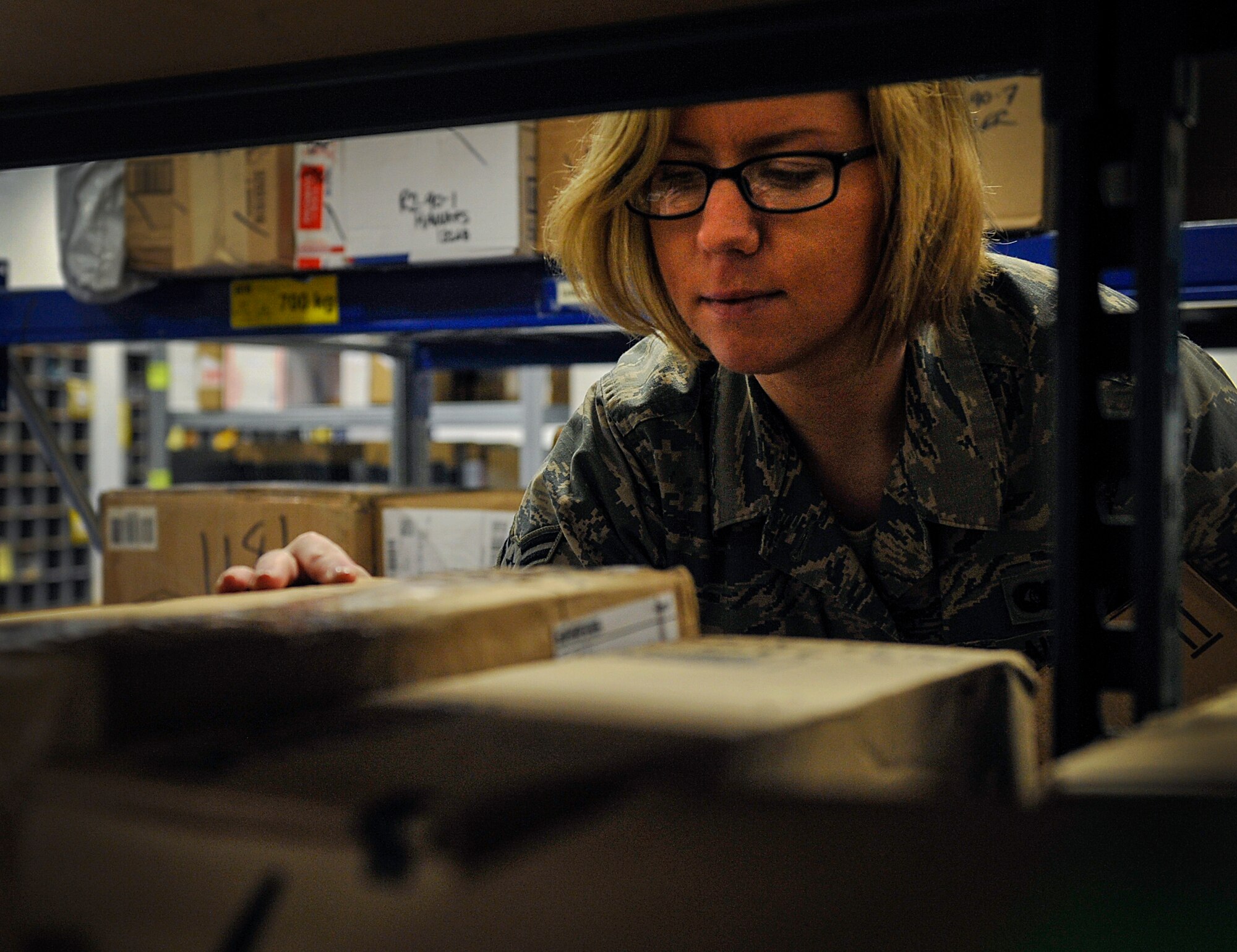 Airman 1st Class Kara Woods, 86th Communications Squadron postal specialist, searches for a customer’s package at the Northside post office April 5, 2016, at Ramstein Air Base, Germany. Woods works at the Northside post office and is a part of the base Honor Guard, though she originally had planned to become a Marine. She said she is grateful for the opportunities the Air Force has given her. (U.S. Air Force photo/Senior Airman Larissa Greatwood)
