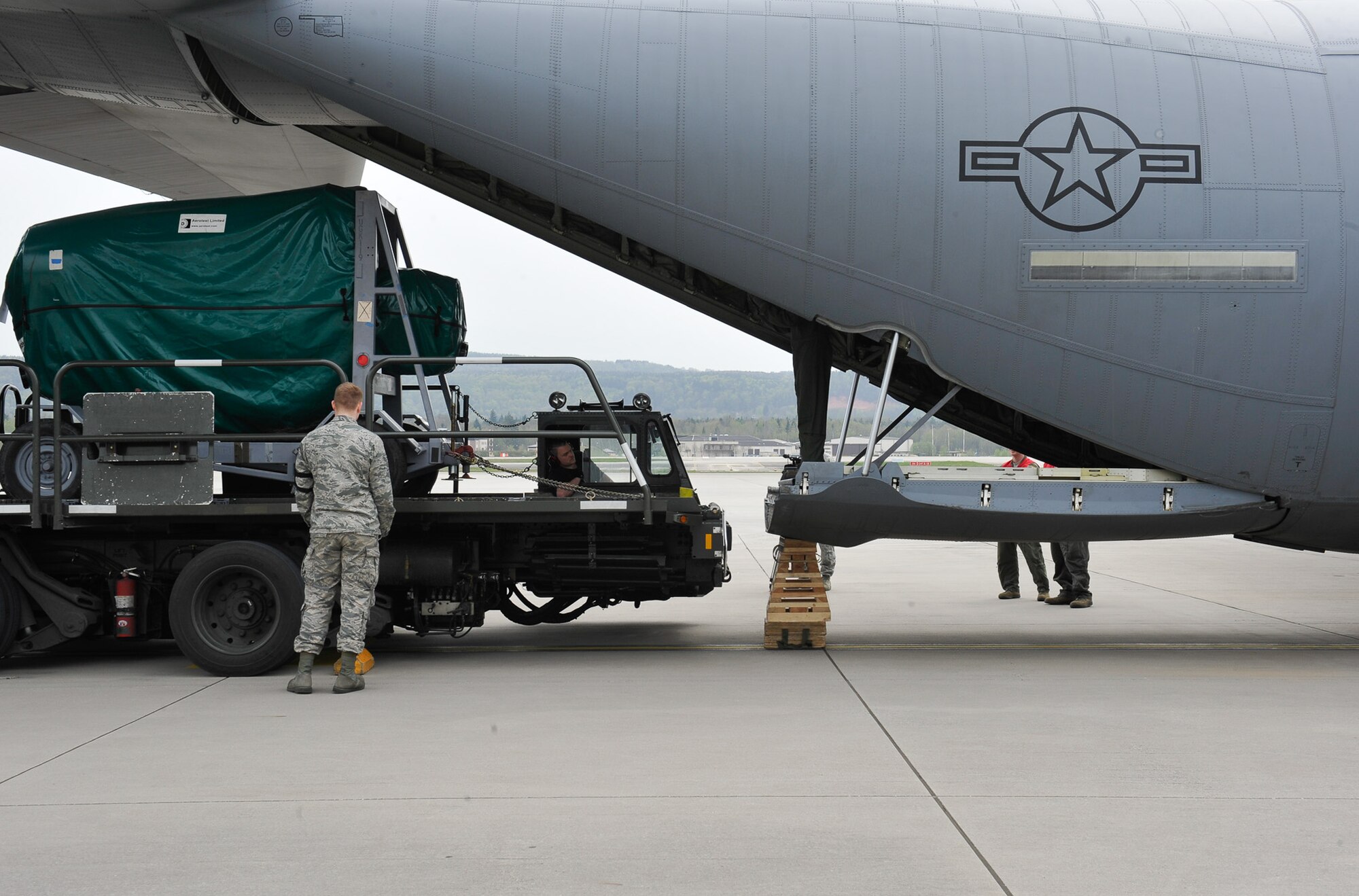 An Airman from the 86th Aircraft Maintenance Squadron stands by to assist in loading cargo onto a C-130J Super Hercules during Wing Thunder, April 22, 2016, at Ramstein Air Base, Germany. Team Ramstein conducted the inspection, Wing Thunder, to exercise the 86th Airlift Wing’s readiness and operational capabilities April 17 through 27. (U.S. Air Force photo/Staff Sgt. Leslie Keopka)