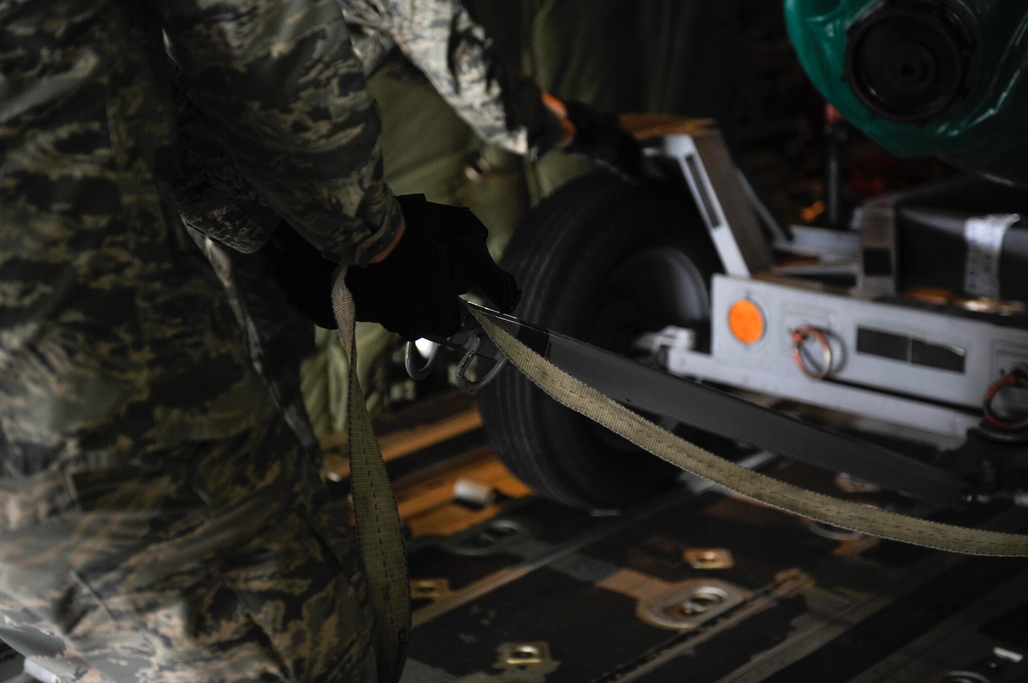 An aircraft maintainer straps down a piece of cargo onboard a C-130J Super Hercules after being loaded in support of Wing Thunder April 22, 2016, at Ramstein Air Base, Germany. The cargo loaded was to test the operational readiness of aircrew during real-world and exercise scenarios. (U.S. Air Force photo/Staff Sgt. Leslie Keopka) 