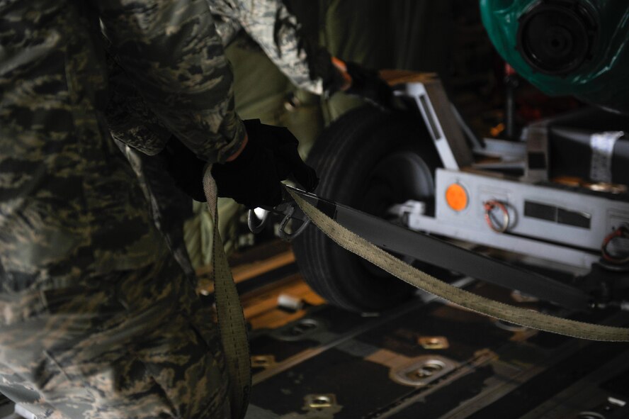 An aircraft maintainer straps down a piece of cargo onboard a C-130J Super Hercules after being loaded in support of Wing Thunder April 22, 2016, at Ramstein Air Base, Germany. The cargo loaded was to test the operational readiness of aircrew during real-world and exercise scenarios. (U.S. Air Force photo/Staff Sgt. Leslie Keopka) 