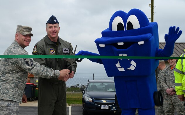 Col. David Eaglin, 48th Fighter Wing vice command, Chief Master Sgt. Brian Kentta, 48th Mission Support Group superintendent and Chuck-IT, 48th Civil Engineer Squadron recycling center mascot cut the ribbon to the newly expanded recycling facility at Royal Air Force Lakenheath, England, April 22, 2016. The recycling center produces 700 tons of recyclable materials annually, saving the Air Force about $250,000 a year. (U.S. Air Force photo by Senior Airman Dawn M. Weber/Released)