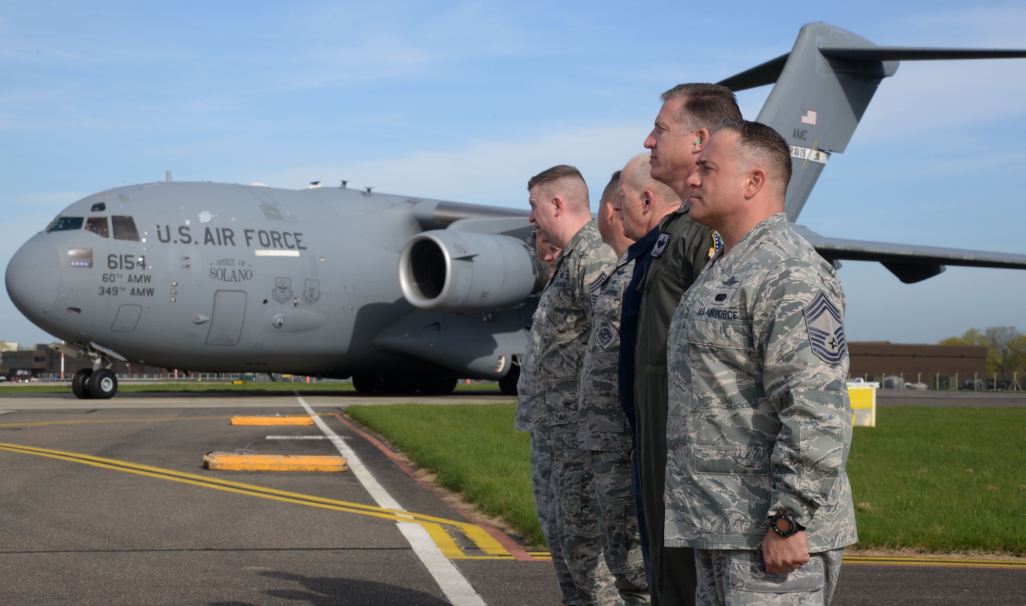 Leadership from RAF Mildenhall and RAF Lakenheath, England stand at attention April 21, 2016, in anticipation of the arrival of distinguished visitors, at RAF Mildenhall, England. A U.S. Air Force C-17 Globemaster III from Travis Air Force Base, Calif. transported guests to attend the AF Civic Leader Program tour. (U.S. Air Force photo by Senior Airman Justine Rho/Released)