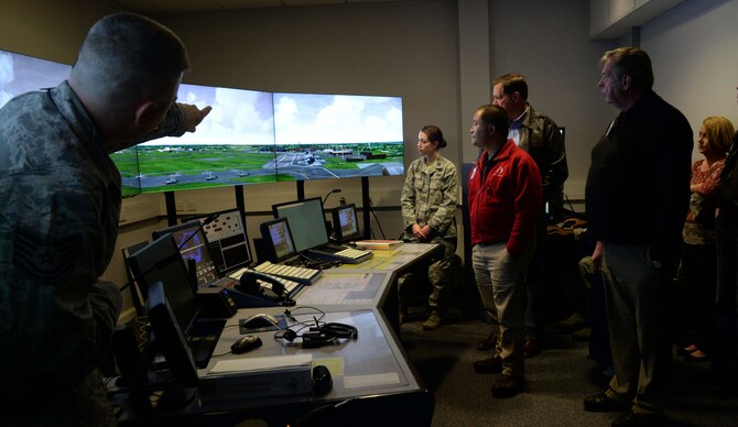 U.S. Air Force Tech Sgt. Michael Lantz, 100th Operations Support Squadron Air Traffic Control watch supervisor, left, points out an aircraft arrival on the 100th OSS ATC simulator April 22, 2016, to civic leaders during their tour of RAF Mildenhall, England. The civic leaders were given the opportunity to test out their skills as air traffic controllers on the simulator. (U.S. Air Force photo by Senior Airman Justine Rho/Released)