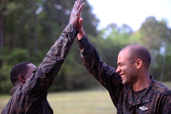 A Marine and sailor with Combat Logistics Regiment 2, celebrate with a high-five after completing an endurance course at Camp Lejeune, N.C., April 22, 2016. The unit pushed through the grueling 3.4 mile course to improve their ability to work as a team and to build camaraderie.