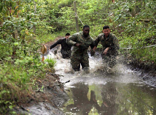 Marines with Combat Logistics Regiment 2 splash their way through one of the many mud puddles during an endurance course at Camp Lejeune, N.C., April 22, 2016. The unit pushed through the grueling 3.4 mile course to improve their ability to work as a team and to build camaraderie.