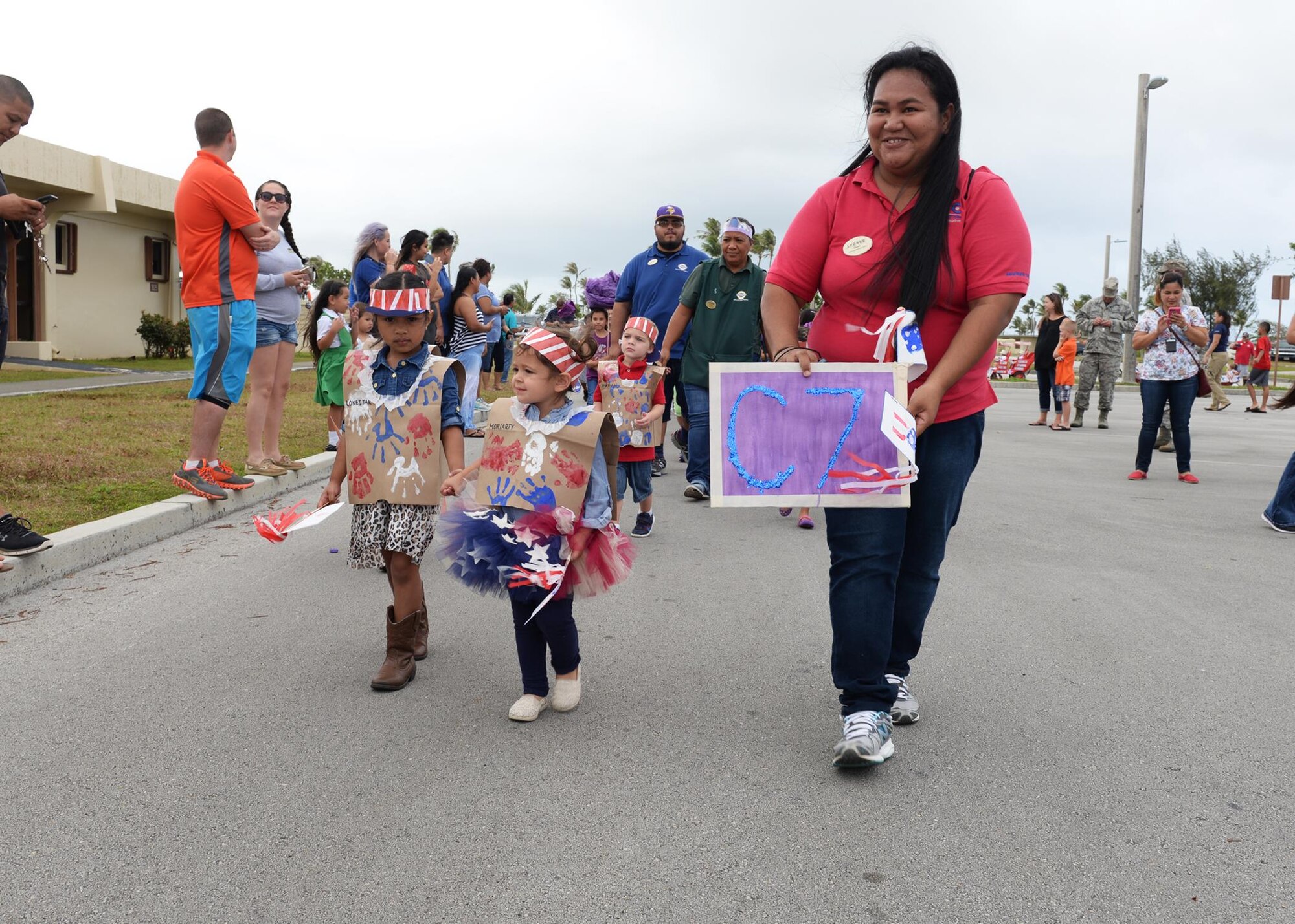 Children walk in a parade to celebrate the Month of the Military Child April 8, 2016, at Andersen Air Force Base, Guam. Throughout the week the children created themed art and designed purple shirts to signify the support of each military branch. (U.S. Air Force photo by Senior Airman Cierra Presentado/Released)