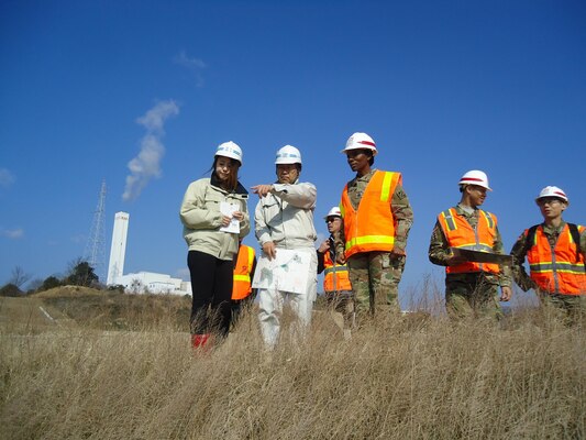 A Japanese contractor explains how the ground is being prepared to support the planned structures on Marine Corps Air Station Iwakuni, Japan to Command Sgt. Major Yolanda Tate.