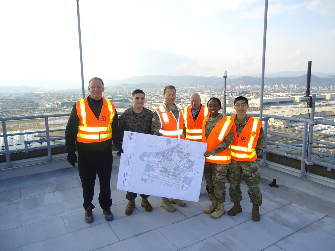 U.S. Army Corps of Engineers, Japan District Iwakuni Resident Office personnel, Marine Corps Air Station Iwakuni Marines and Command Sgt. Major Yolanda Tate pose for a photo on the roof of the control tower. 