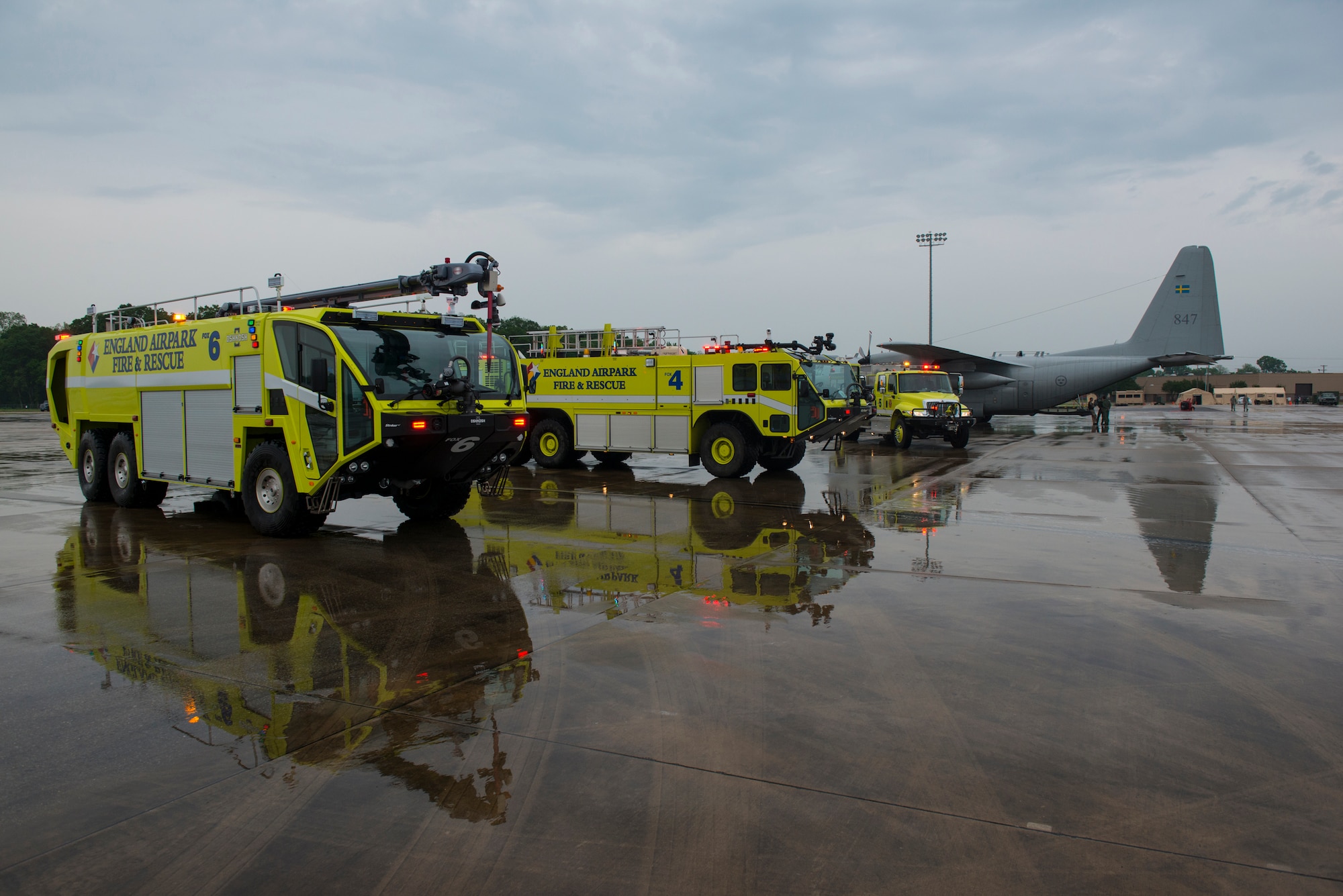 England Airpark fire and rescue trucks sit near a Swedish C-130 Hercules after an emergency response exercise during a Joint Readiness Training exercise at Alexandria International Airport, La. April 18, 2016. JRTC is a multinational exercise focused on pre-deployment and airdrop capabilities. (U.S. Air Force photo by Senior Airman Joshua King)