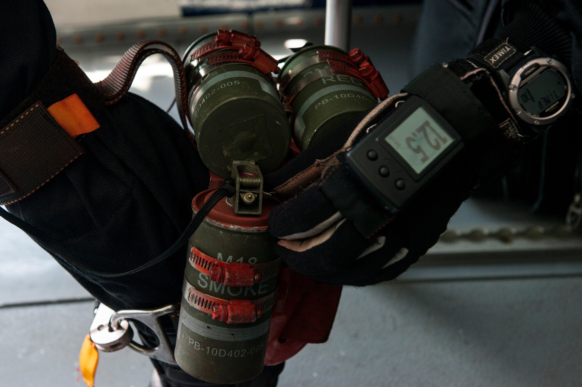A U.S. Army Golden Knight prepares smoke bombs before parachuting down to Langley Air Force Base, Va., April 24, 2016. The U.S. Army Soldiers who wear the black and gold uniform of the U.S. Army Parachute Team represent the “Band of Excellence” and warrior ethos that all Soldiers demonstrate. (U.S. Air Force photo by Airman 1st Class Derek Seifert)