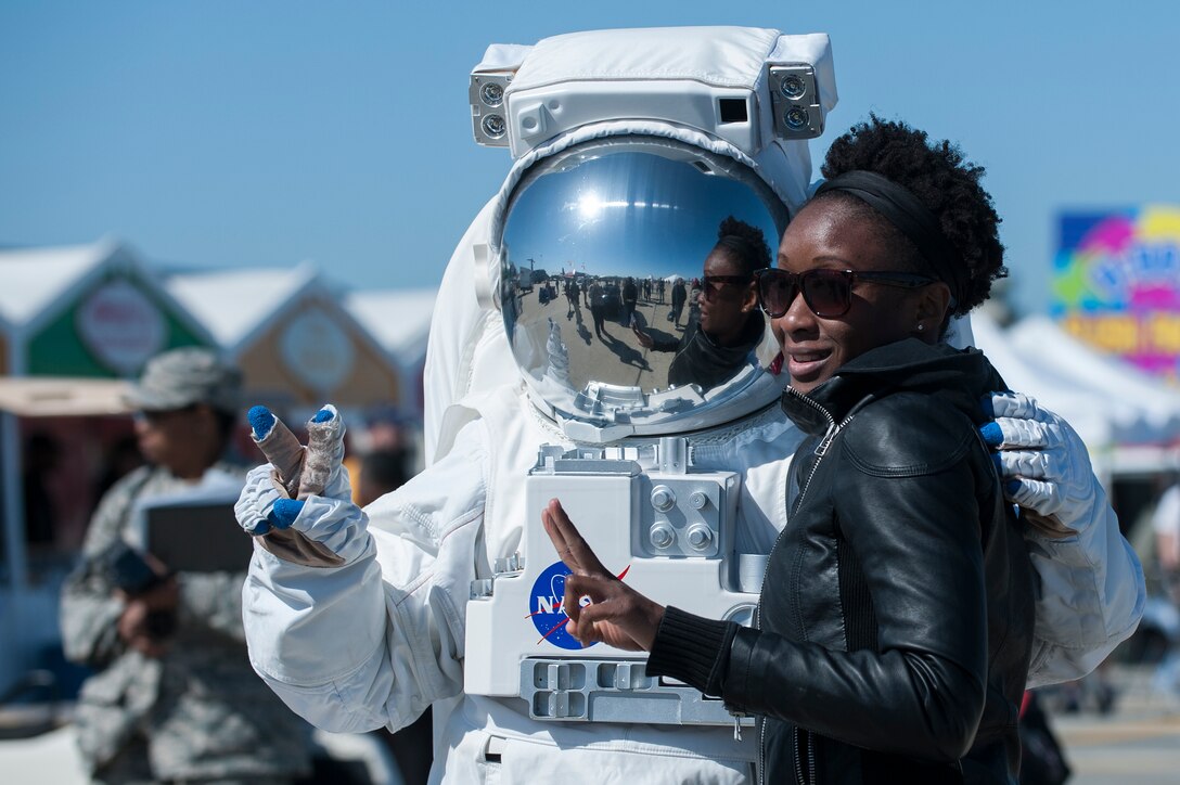 An AirPower over Hampton Roads Open House attendee poses with a NASA astronaut at Langley Air Force Base, Va., April 24, 2016. The NASA Langley Research Center provided educational and entertaining opportunities for open house attendees with tents featuring science, space and aviation exhibits. (U.S. Air Force photo by Airman 1st Class Kaylee Dubois)