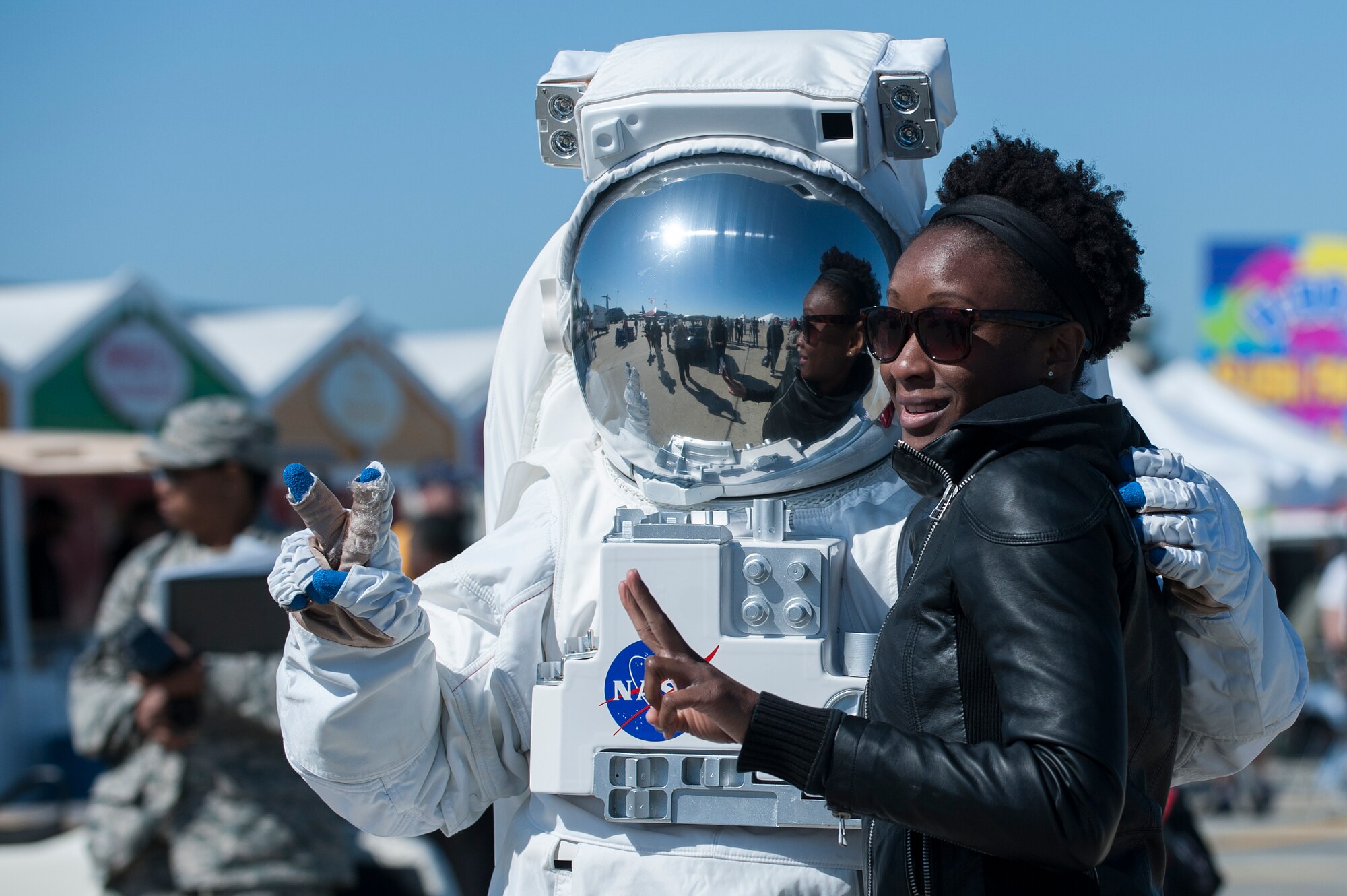 An AirPower over Hampton Roads Open House attendee poses with a NASA astronaut at Langley Air Force Base, Va., April 24, 2016. The NASA Langley Research Center provided educational and entertaining opportunities for open house attendees with tents featuring science, space and aviation exhibits. (U.S. Air Force photo by Airman 1st Class Kaylee Dubois)