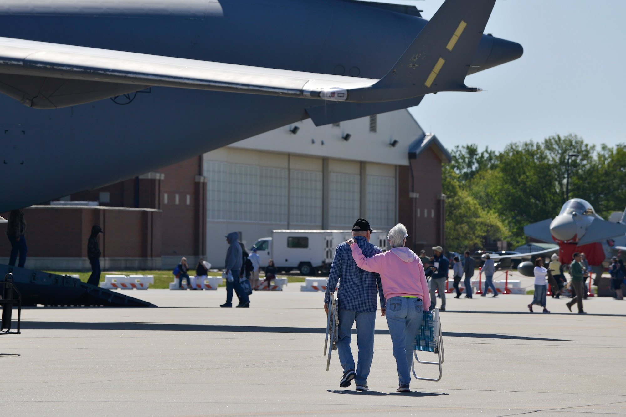 A couple walks side-by-side during the AirPower over Hampton Roads Open House at Langley Air Force Base, Va., April 24, 2016. While the first and second days of the show were rained out early, spectators were able to enjoy the show in its entirety on Sunday. (U.S. Air Force photo by Staff Sgt. Natasha Stannard)