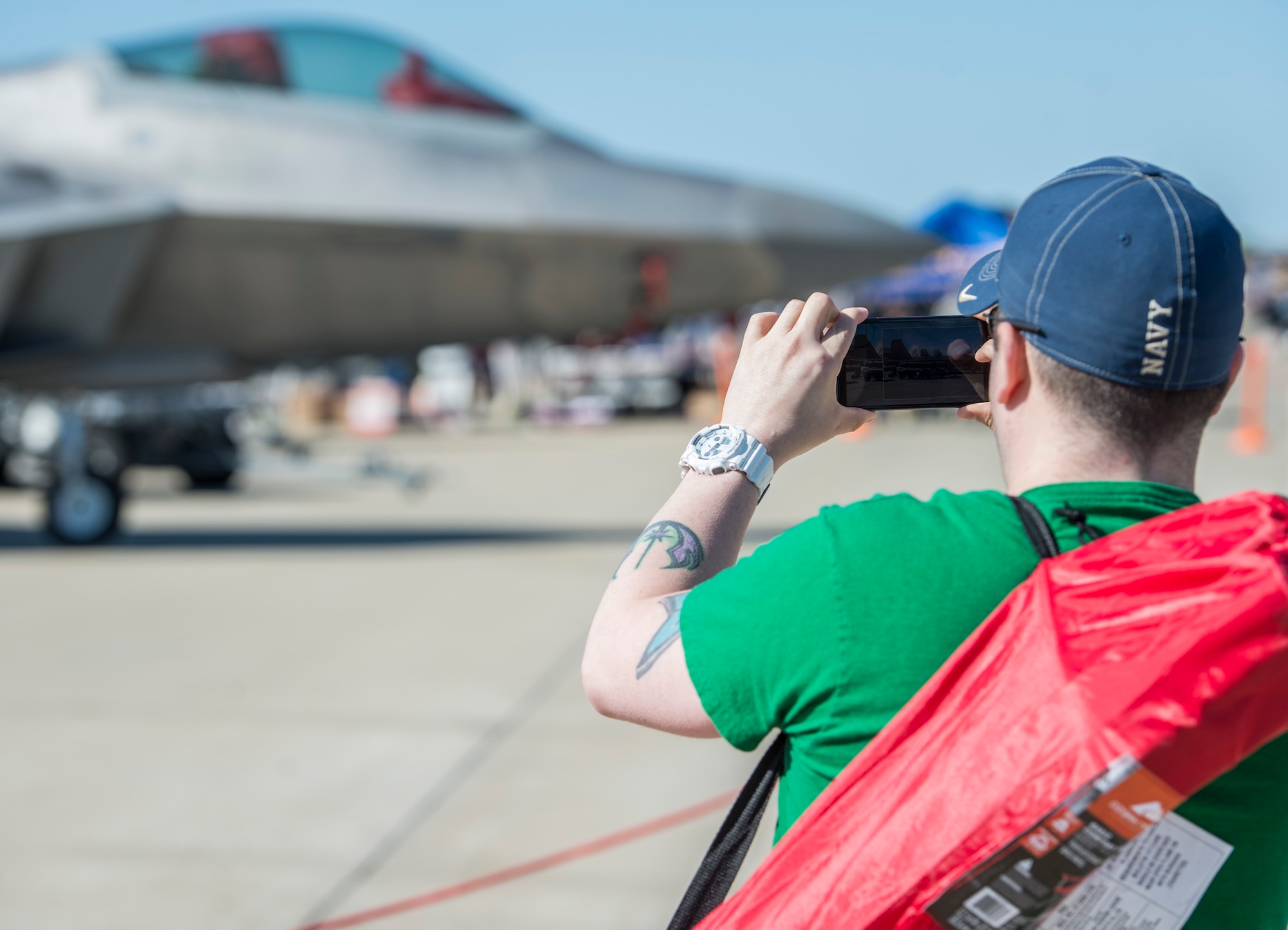 An AirPower Over Hampton Roads Open House patron takes a picture of the F-22 Raptor at Langley Air Force Base, Va., April 24, 2016. The Raptor is the Air Force's newest fighter aircraft and its combination of stealth, super cruise, maneuverability, and integrated avionics coupled with improved supportability, represents an exponential leap in war-fighting capabilities. (U.S. Air Force photo by Senior Airman Kayla Newman)