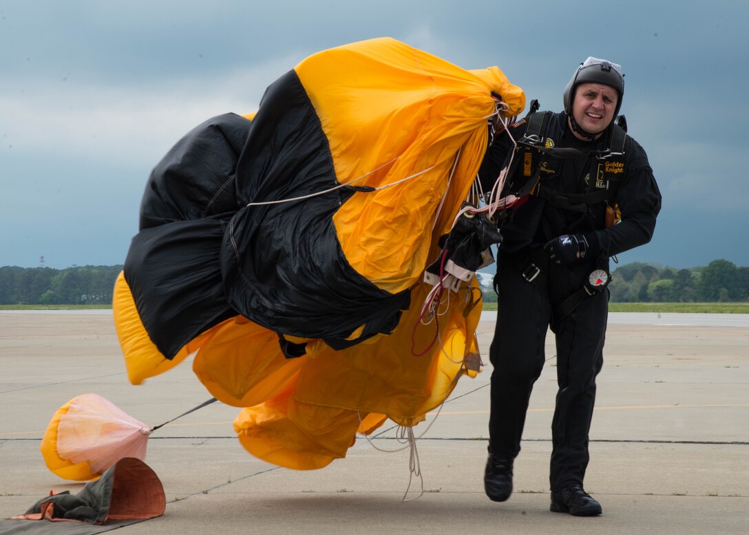 U.S. Army Spc. Jason Wenger, an aviation maintainer assigned to the U.S. Army Golden Knights parachute team, gathers his parachute after landing during the Airpower Over Hampton Roads Open House at Langley Air Force Base, Va., April 24, 2016. The Golden Knights are composed of approximately 95 men and women, which include four parachute units, an aviation unit and a headquarters. (U.S. Air Force Photo by Staff Sgt. J.D. Strong II)
