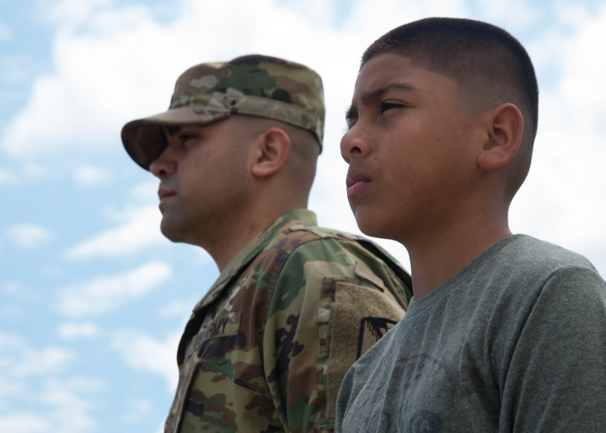 U.S. Army Staff Sgt. Francisco Gallegos, an Advance Individual Training instructor assigned to the 122nd Aviation Regiment stand at attention with his son, Angel Alexander Gallegos, as Taps plays during the Airpower Over Hampton Roads Open House at Langley Air Force Base, Va., April 24, 2016. Airpower Over Hampton Roads was the Gallegos family’s first open house experience. (U.S. Air Force Photo by Staff Sgt. J.D. Strong II)