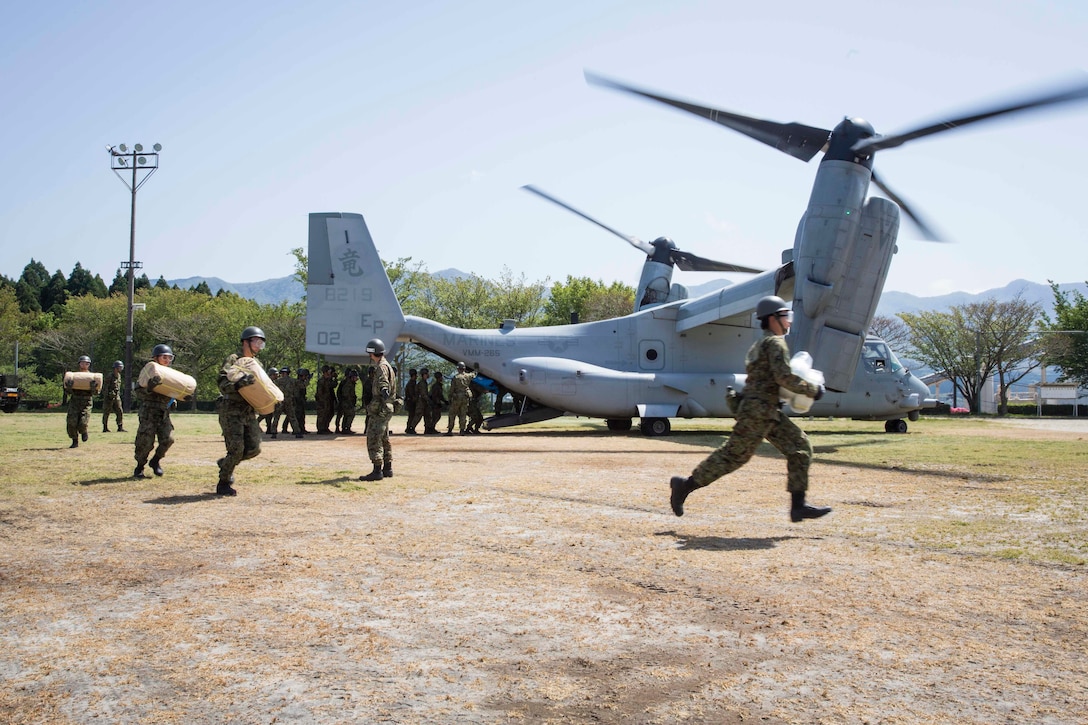 Japanese soldiers carry supplies from a U.S. Marine Corps MV-22B Osprey aircraft at the Hakusui Sports Park, Kyushu Island, Japan, April 22, 2016. The Marines and aircraft are assigned to Marine Medium Tiltrotor Squadron 265, 31st Marine Expeditionary Unit. The humanitarian aid is part of the relief effort after a series of earthquakes struck the island. Marine Corps photo by Cpl. Darien J. Bjorndal