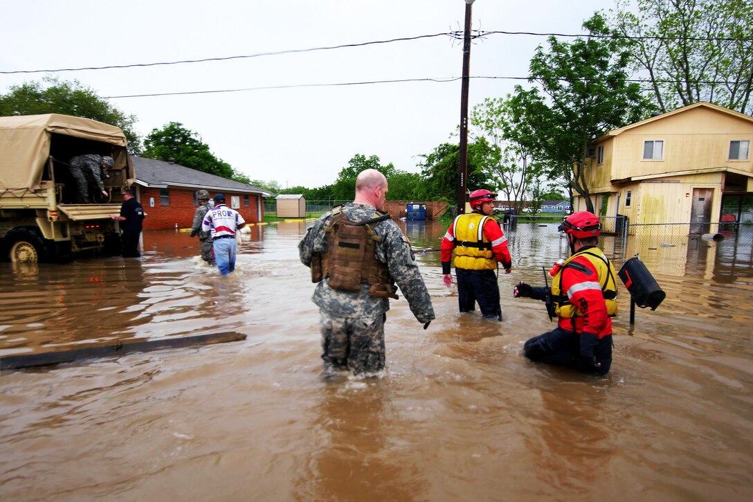 Soldiers and Texas Task Force 1 rescue personnel wade through deep water to help stranded residents during severe flooding in Wharton, Texas, April 21, 2016. The soldiers are assigned to the Texas Army National Guard’s Company D, 536th Brigade Support Battalion. Texas Army National Guard photo by 1st Lt. Zachary West