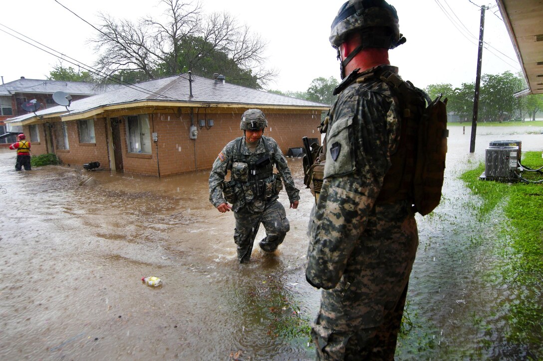 Soldiers and Texas Task Force 1 rescue personnel wade through deep water conducting house-to-house searches for stranded residents during severe flooding in Wharton, Texas, April 21, 2016. Texas Army National Guard photo by 1st Lt. Zachary West