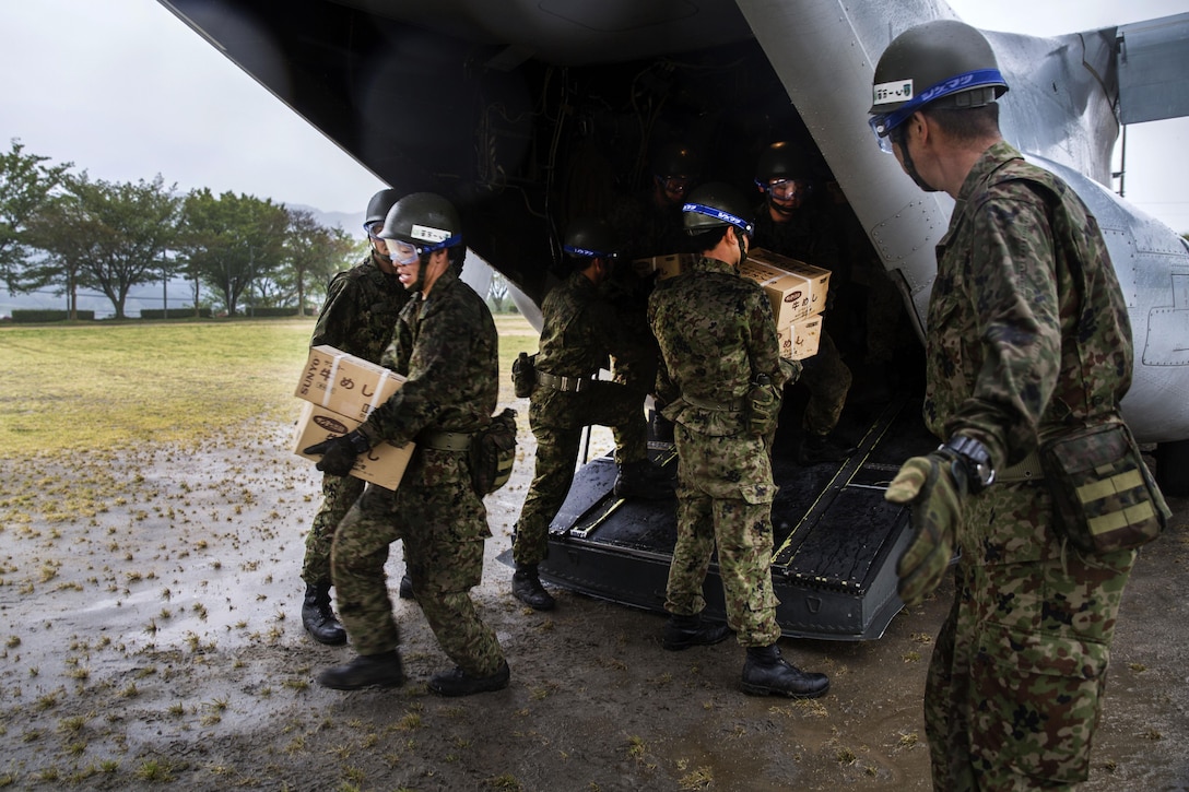 Japanese soldiers unload supplies from a U.S. Marine Corps MV-22B Osprey aircraft at the Hakusui Sports Park, Kyushu Island, Japan, April 23, 2016. Marine Corps photo by Cpl. Nicole Zurbrugg