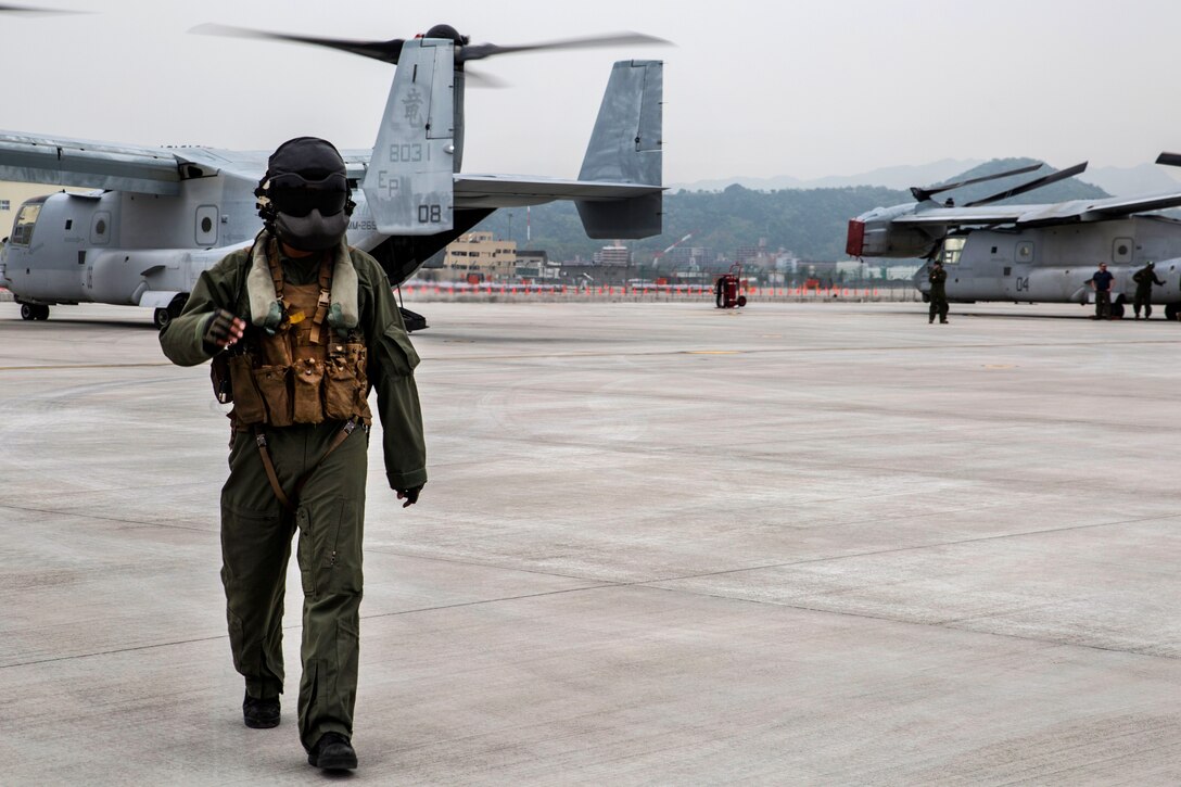 A Marine Corps crew chief walks off the flight line from his U.S. Marine Corps MV-22B Osprey aircraft at Marine Corps Air Station Iwakuni, Japan, after conducting relief supply missions, April 23, 2016. Marine Corps photo by Cpl. Nicole Zurbrugg