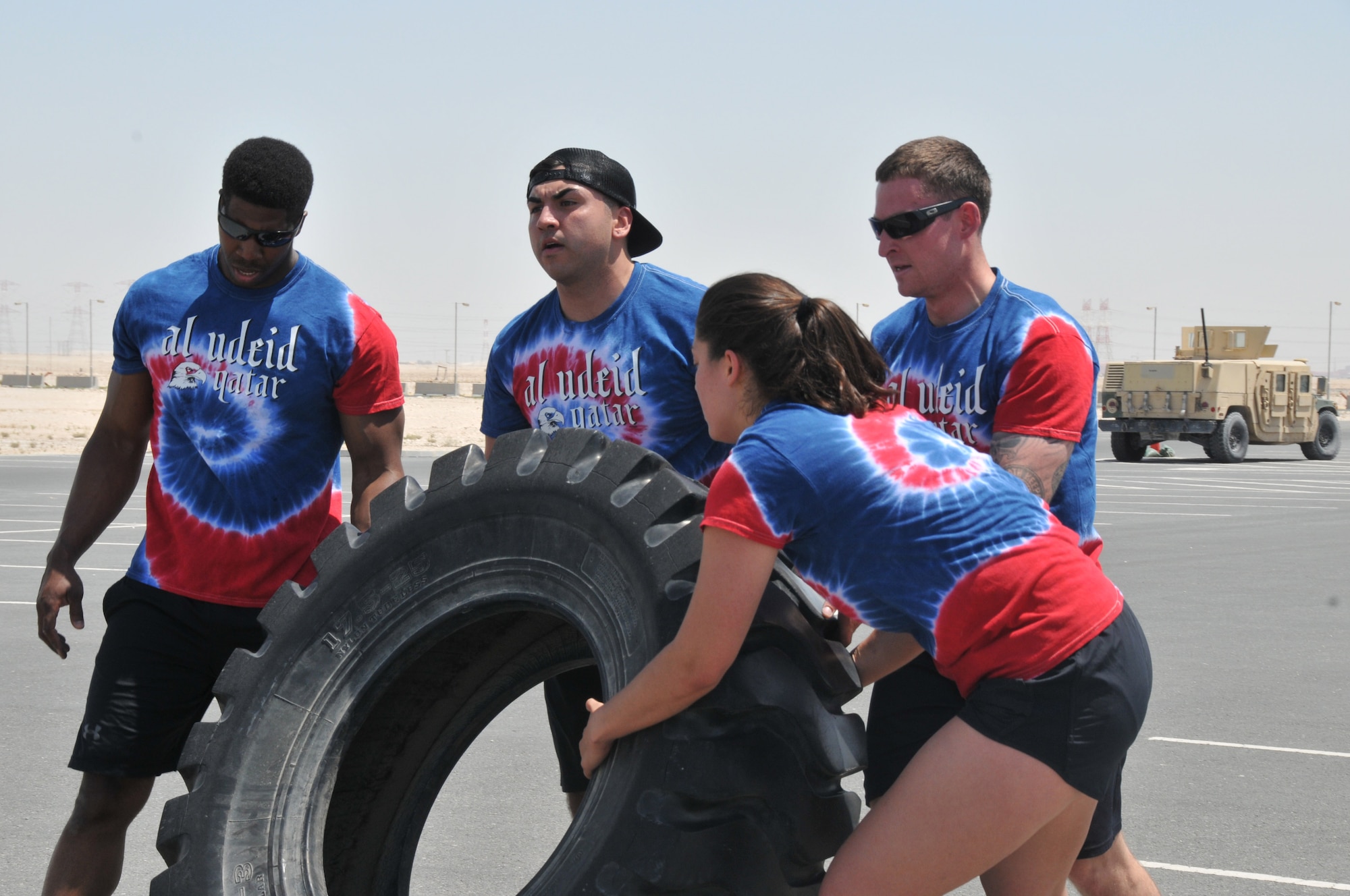 The 379th Expeditionary Security Forces defenders compete in the Defenders Challenge April 21 at Al Udeid Air Base, Qatar. Defenders participate in a tire flip event as a team to get the tire from one end to the next. This event dealt with teamwork and endurance. (U.S. Air Force photo by Tech. Sgt. Terrica Y. Jones/Released)