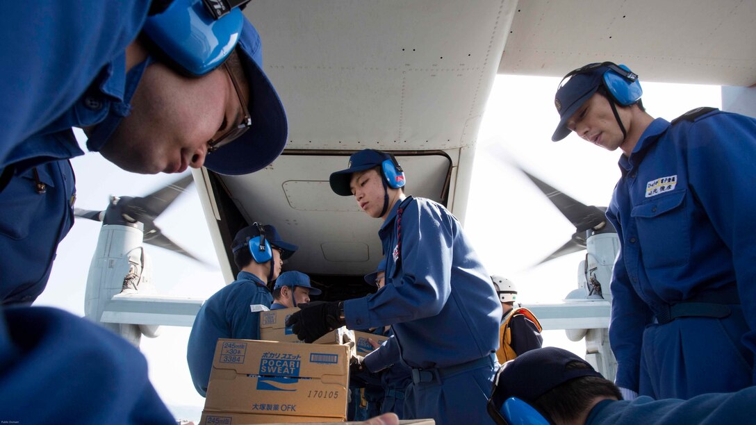 Japan Maritime Self Defense Force personnel load supplies onto a U.S. Marine Corps MV-22B Osprey tiltrotor aircraft from Marine Medium Tiltrotor Squadron 265 (Reinforced), 31st Marine Expeditionary Unit aboard the JS Hyuga, at sea, April 22, 2016. The supplies are in support of relief efforts after a series of earthquakes struck the island of Kyushu.