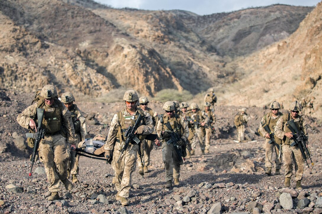 Marines and sailors carry a person with simulated injuries to an extraction point during training for tactical recovery of aircraft and personnel in Djibouti, April 19, 2016. The troops are assigned to the 13th Marine Expeditionary Unit, which is supporting maritime security operations and theater cooperation efforts in the U.S. 5th fleet area of operations. Marine Corps photo by Sgt. Hector de Jesus