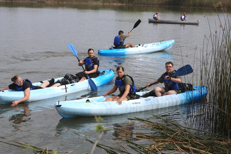 Volunteers with the Single Marine Program use kayaks to clear vegetation from the banks of the Miramar Fish Pond aboard Marine Corps Air Station Miramar, Calif., April 22. Fifty Marines participated in the SMP's 2nd Annual Day of Service pond cleanup. (U.S. Marine Corps photo by Pfc. Liah Kitchen/Released)