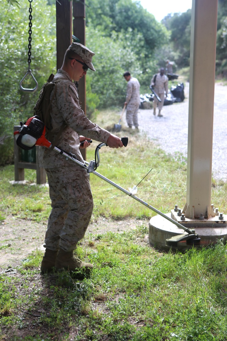 A Marine volunteering with the Single Marine Program clears vegetation from a sitting area around the Miramar Fish Pond aboard Marine Corps Air Station Miramar, Calif., April 22. Fifty Marines participated in the SMP's 2nd Annual Day of Service pond cleanup. (U.S. Marine Corps photo by Pfc. Liah Kitchen/Released)