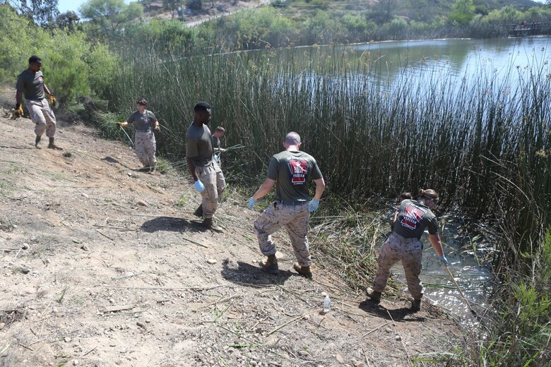 Marines volunteering with the Single Marine Program clear vegetation from the bank of the Miramar Fish Pond aboard Marine Corps Air Station Miramar, Calif., April 22. Fifty Marines participated in the SMP's 2nd Annual Day of Service pond cleanup. (U.S. Marine Corps photo by Pfc. Liah Kitchen/Released)