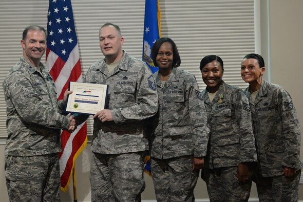 Col. Andrew Bernard, 4th Fighter Wing vice commander, presents the 4th Force Support Squadron Airman Leadership School staff with the Governor’s Volunteer Service Award, April 20, 2016, at Seymour Johnson Air Force Base, North Carolina. The ALS staff received the award for their many hours of service to the community. (U.S. Air Force photo by Airman 1st Class Ashley Williamson/Released)