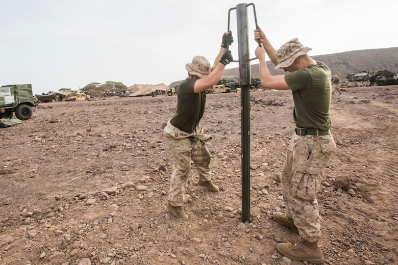 U.S. Marines with the 13th Marine Expeditionary Unit ram a pike into the ground as they build their encampment in Djibouti, Apr. 9, 2016. The 13th MEU is conducting sustainment training to maintain proficiency and combat readiness while deployed with the Boxer Amphibious Ready Group during Western Pacific Deployment 16-1. (U.S. Marine Corps photo by Cpl. Alvin Pujols/RELEASED)