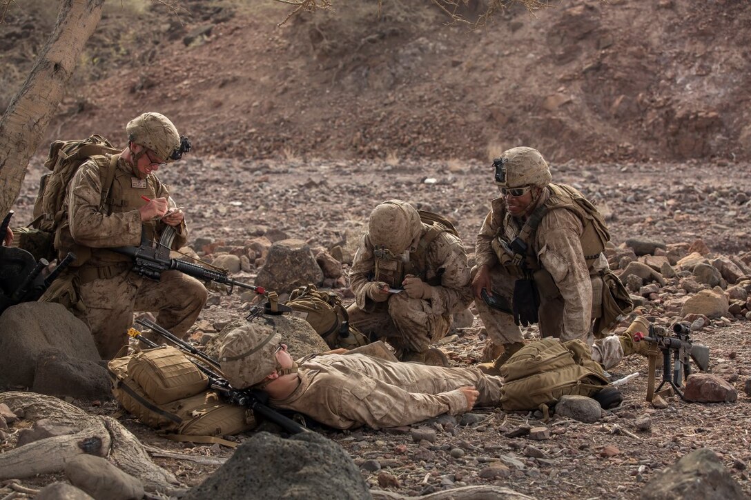U.S. Marines and Sailors with the 13th Marine Expeditionary Unit assess a simulated injured isolated person before moving to the extraction point during Tactical Recovery of Aircraft and Personnel training at Training Area Bravo 1, Djibouti, Africa, April 19, 2016. The 13th MEU is deployed in support of maritime security operations and theater cooperation efforts in the U.S. 5th fleet area of operations. (U.S. Marine Corps photo by Sgt. Hector de Jesus/RELEASED)