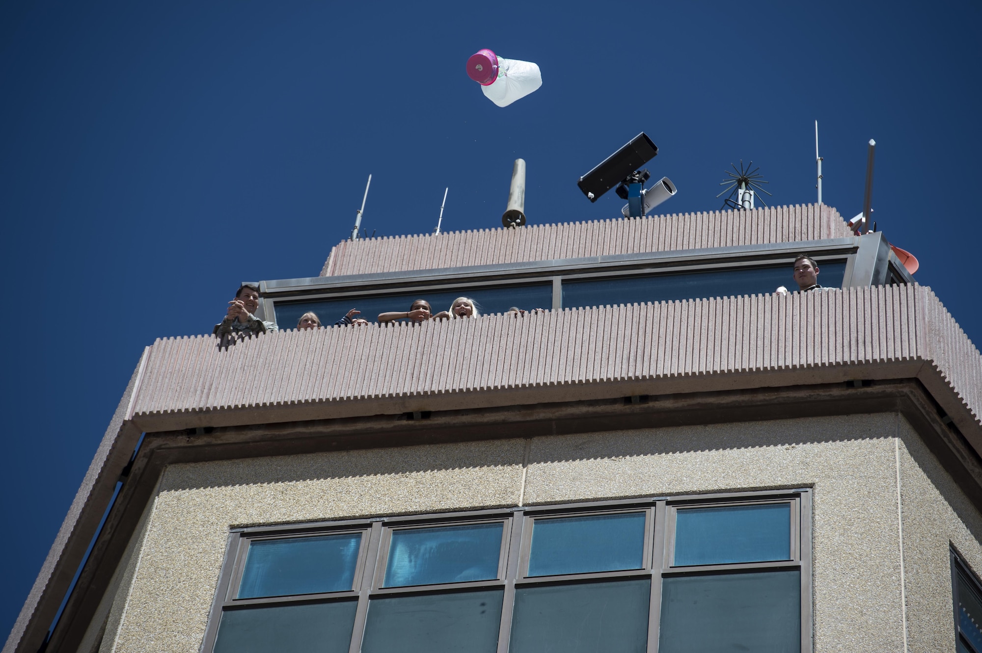 Students from Holloman Elementary School participate in an egg drop science project, April 14. The students threw eggs surrounded in a protective apparatus from the top of the air traffic control tower at Holloman Air Force Base, N.M. The egg drop project challenges students to create a contraption that will keep an egg safe from impact after being dropped from a tall building, in this case, 14 stories. Typically eggs are dropped from the participating school’s roof. Holloman students had the unique opportunity to utilize the air traffic control tower for this project. (U.S. Air Force photo by Senior Airman Aaron Montoya)