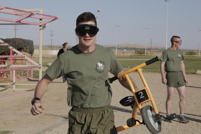 Lance Cpl. Ethan Eisenmann, tank crewman, 1st Tank Battalion, takes his turn running around the track with a tricycle while wearing beer goggles, which simulated impaired vision associated with intoxication, during the Substance Abuse Program’s Scavenger Hunt at Del Valle Field April 15, 2016. (Official Marine Corps photo by Pfc. Dave Flores/Released)