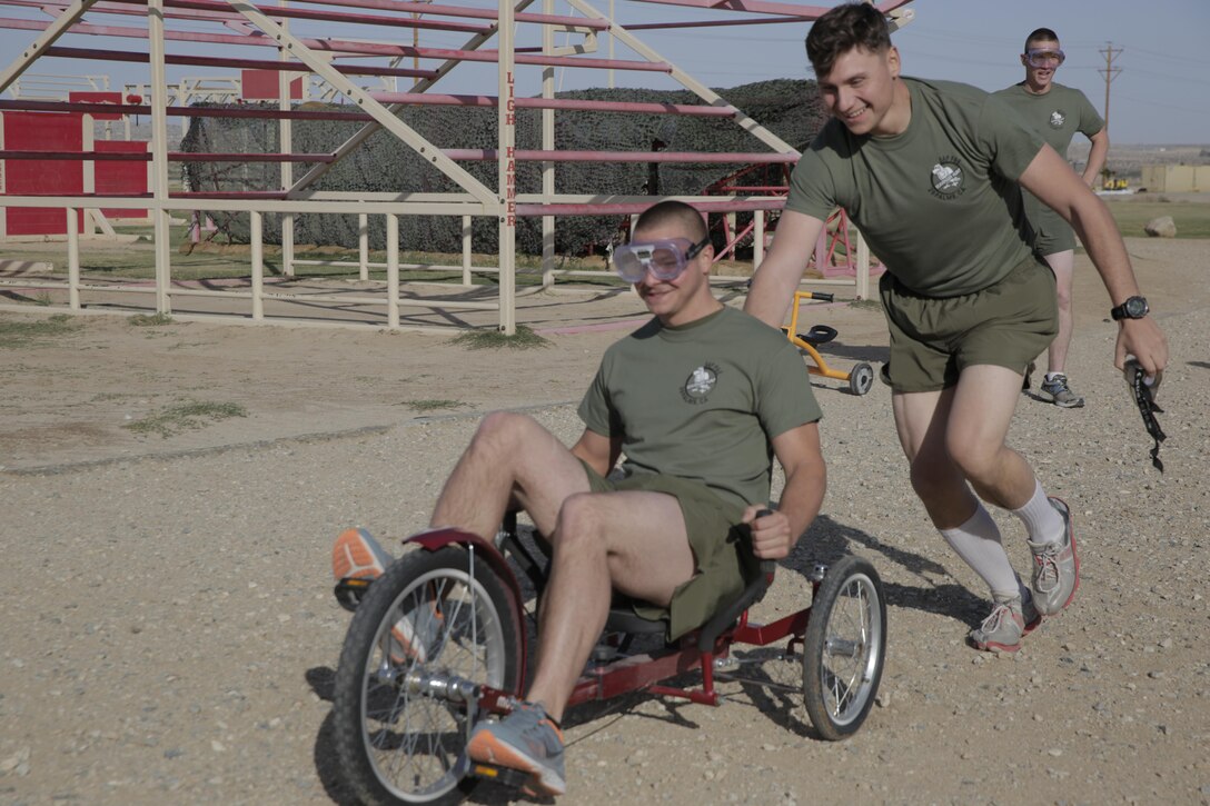 Cpl. Jimmy Carter, rifleman, 2nd Battalion, 7th Marine Regiment, pushes his teammate Pfc. James Swain, motor technician operator, 2/7, during the Substance Abuse Program’s Scavenger Hunt April 15, 2016. (Official Marine Corps photo by Pfc. Dave Flores/Released)