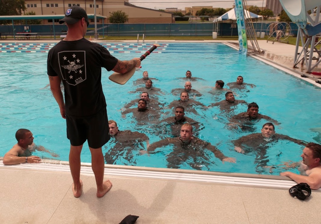 Chief Petty Officer Eric S. Gilmet (standing), a Fleet Marine Force reconnaissance corpsman and Inspector-Instructor medical staff with 4th Reconnaissance Battalion, 4th Marine Division, Marine Forces Reserve, speaks to Sailors from across Marine Forces Reserve and the U.S. Navy Reserve during a water confidence exercise at a FMF reconnaissance corpsman screening in San Antonio, April 19, 2016. The screening was hosted by 4th Reconnaissance Bn. for Reserve Sailors to gain familiarity with the demands of the FMF reconnaissance corpsman pipeline.