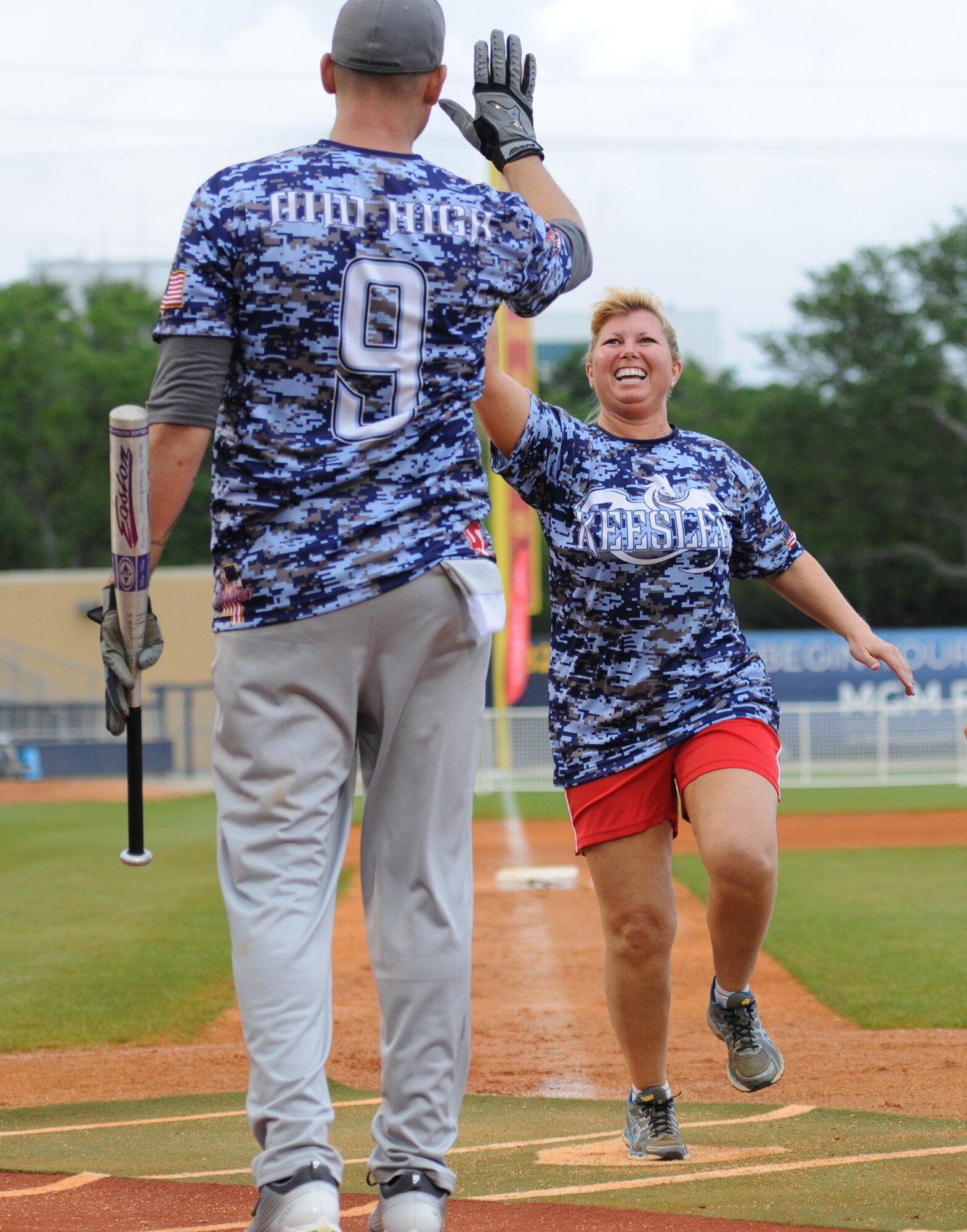 Lt. Col. Betsy Ross, 81st Mission Support Group deputy commander and “Boots” team member, gives a high-five to her teammate, Senior Master Sgt. Zackery Turbyfill, 81st Training Group military training leader superintendent, during the “Boots versus Badges” softball game at the Biloxi Shuckers MGM Park April 21, 2016, Biloxi, Miss. The game was the kickoff event for the 2016 Special Olympics Mississippi Summer Games, which will be hosted by Keesler Air Force Base, Miss., May 20-21. (U.S. Air Force photo by Kemberly Groue)