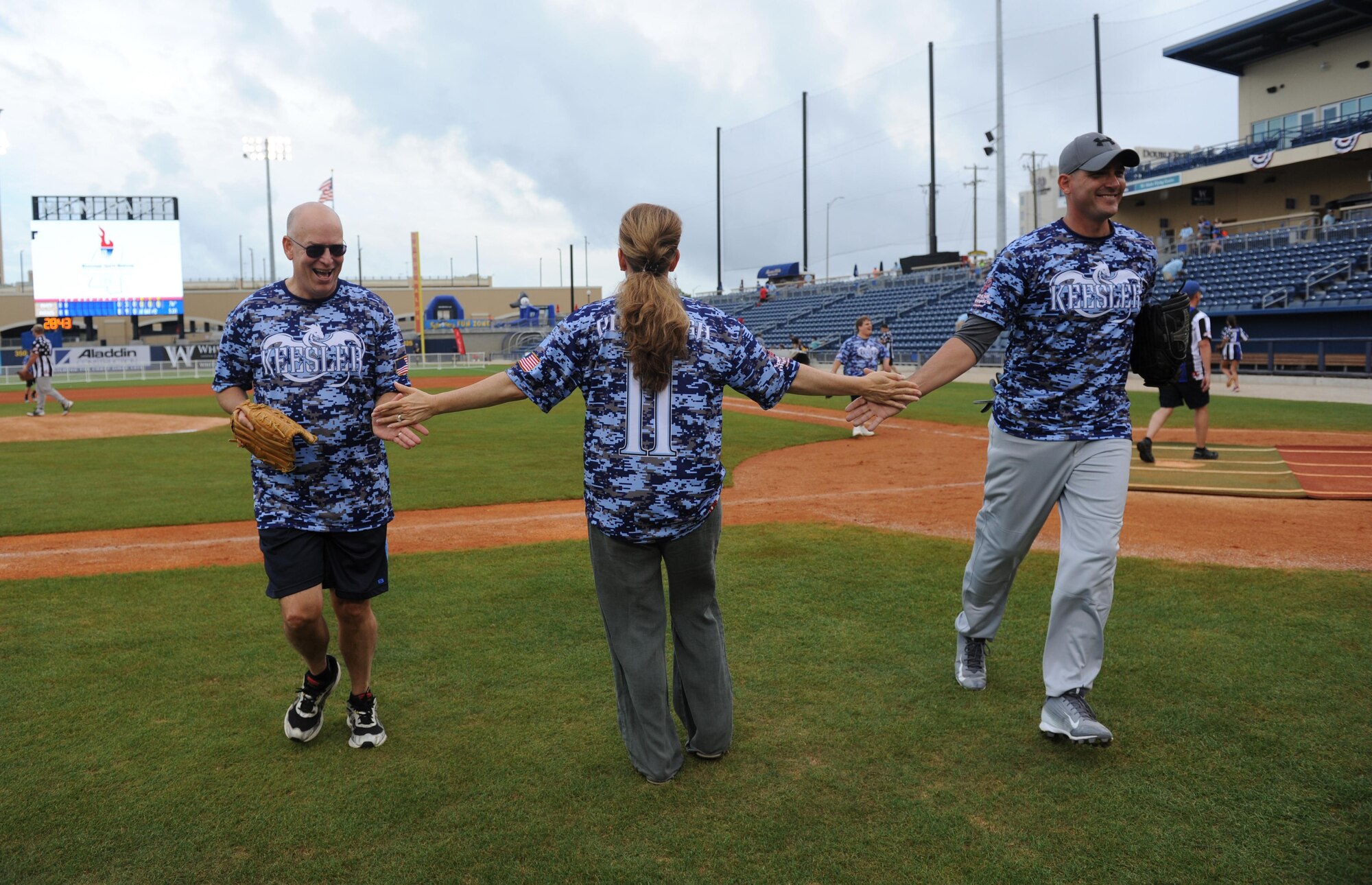 Col. Michele Edmondson, 81st Training Wing commander and “Boots” team coach, gives high-fives to her teammates, Col. Thomas Harrell, 81st Medical Group commander, and Senior Master Sgt. Zackery Turbyfill, 81st Training Group military training leader superintendent, as they leave the field during the “Boots versus Badges” softball game at the Biloxi Shuckers MGM Park April 21, 2016, Biloxi, Miss. The game was the kickoff event for the 2016 Special Olympics Mississippi Summer Games, which will be hosted by Keesler Air Force Base, Miss., May 20-21. (U.S. Air Force photo by Kemberly Groue)