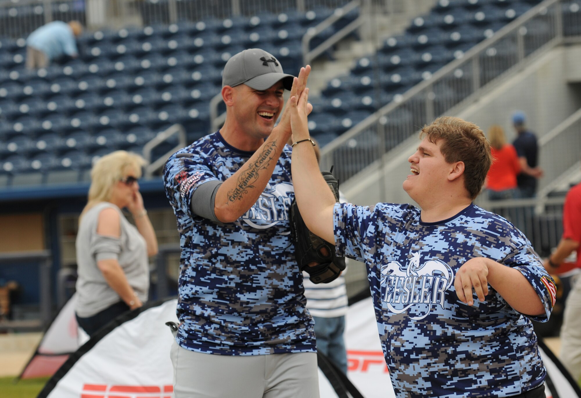 Senior Master Sgt. Zackery Turbyfill, 81st Training Group military training leader superintendent, gives a high-five to Zachery Cerone, Special Olympics athlete, as they warm-up during the “Boots versus Badges” softball game at the Biloxi Shuckers MGM Park April 21, 2016, Biloxi, Miss. The game was the kickoff event for the 2016 Special Olympics Mississippi Summer Games, which will be hosted by Keesler Air Force Base, Miss., May 20-21. (U.S. Air Force photo by Kemberly Groue)