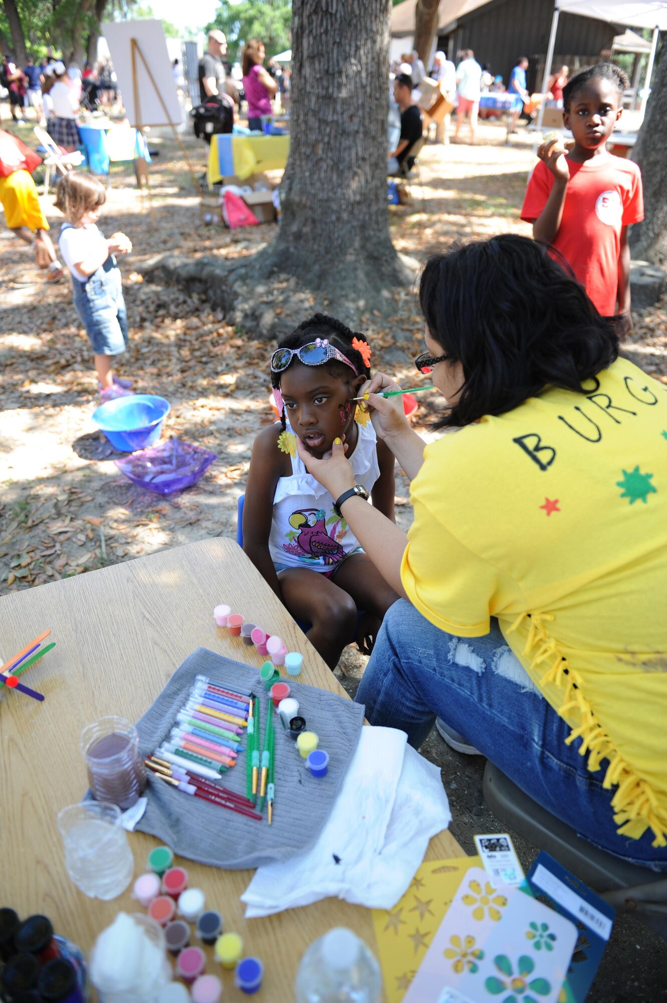 Alesiya Blockett, daughter of U.S. Marine Corps Staff Sgt. Alonzo Blockett, Keesler Marine Detachment instructor, gets her face painted by Angela Burgos, Keesler Family Child Care provider, during Child Pride Day at marina park April 23, 2016, Keesler Air Force Base, Miss. Keesler families attended the annual event which featured activities, demonstrations and information on programs focused on care of military families. Child Pride Day was held in conjunction with the month of the military child. (U.S. Air Force photo by Kemberly Groue)