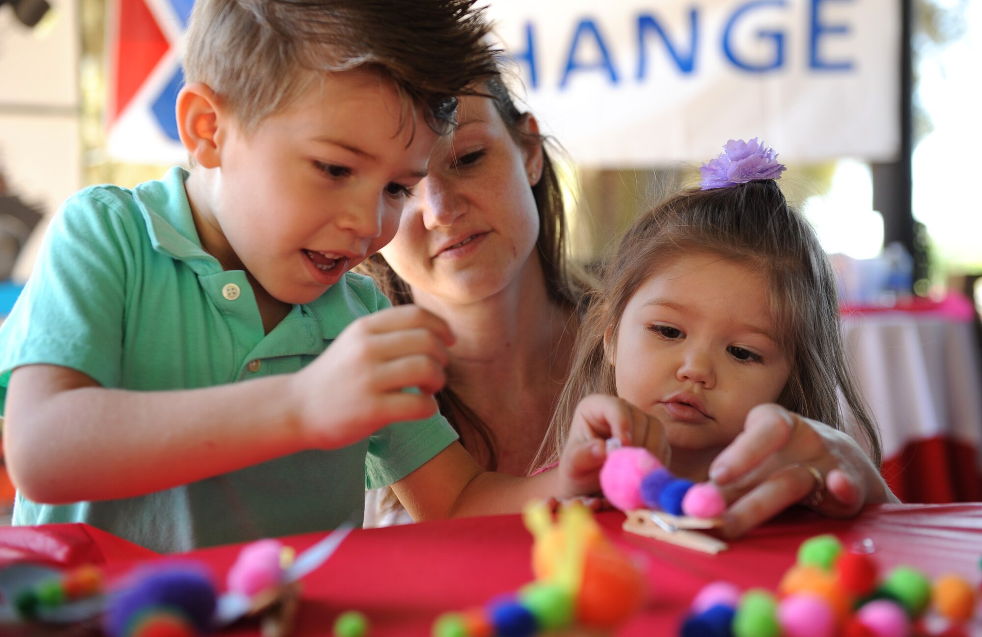 Capt. Sarah Sousa, 81st Inpatient Operation Squadron nurse, assists her kids, Jameson and Brooke, with making a clothes pin caterpillar during Child Pride Day at marina park April 23, 2016, Keesler Air Force Base, Miss. Keesler families attended the annual event which featured activities, demonstrations and information on programs focused on care of military families. Child Pride Day was held in conjunction with the month of the military child. (U.S. Air Force photo by Kemberly Groue)