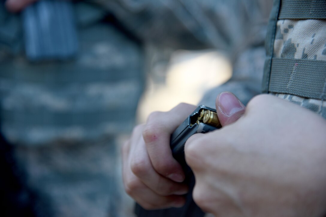 An Angelo State University Air Force ROTC Detachment 847 cadet loads a magazine with blanks during a field training exercise at Camp Sentinel on Goodfellow Air Force Base, Texas, April 22, 2016. The cadets and their adversaries used blanks to simulate a combat enviroment. (U.S. Air Force photo by Senior Airman Joshua Edwards/Released)