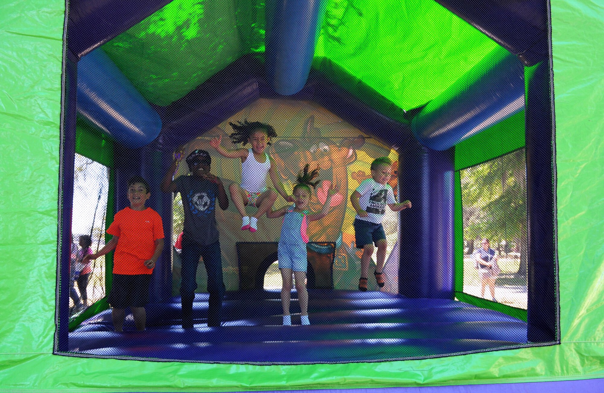 A group of children jump inside a bouncy house during Child Pride Day at marina park April 23, 2016, Keesler Air Force Base, Miss. Keesler families attended the annual event which featured activities, demonstrations and information on programs focused on care of military families. Child Pride Day was held in conjunction with the month of the military child. (U.S. Air Force photo by Kemberly Groue)
