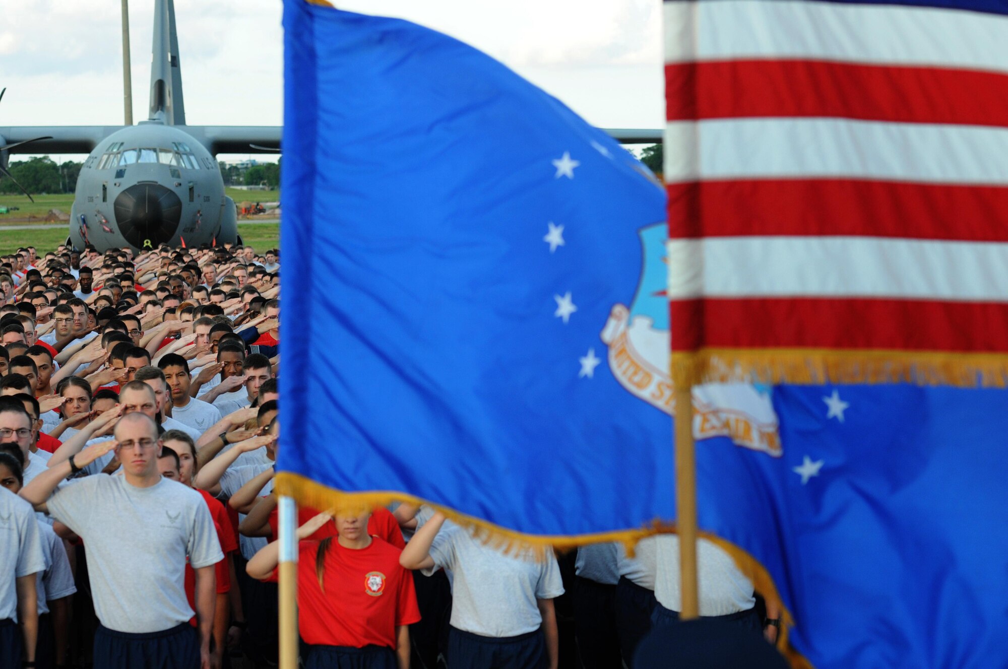 Keesler Airmen render a salute as the national anthem is sung prior to the start of a 5K flightline run April 25, 2016, Keesler Air Force Base, Miss. The run was the kickoff event for a week full of activities supporting Wingman Week. (U.S. Air Force photo by Kemberly Groue)